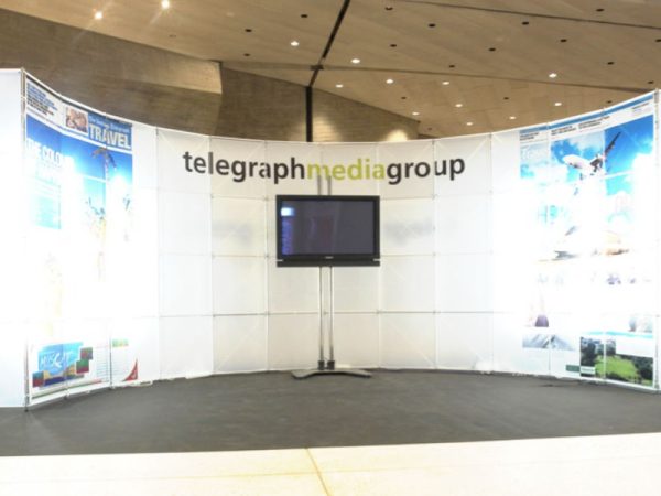 Stand modular curvo con pantalla y paneles impresos montado por Click Comunicación en una feria